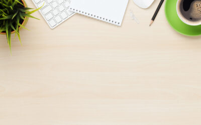 Office table with notepad, computer and coffee cup. View from above with copy space