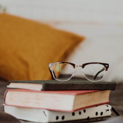 club master eyeglasses on pile of three books